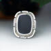 front close up, cushion black onyx gemstone bezel set bead wire and stamped cutout wire accent on tapered wide band